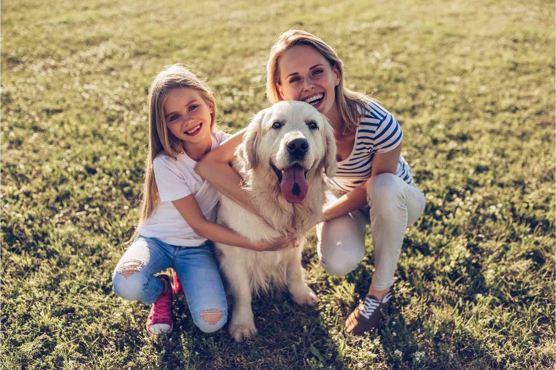 Mother and daughter with older golden retriever dog